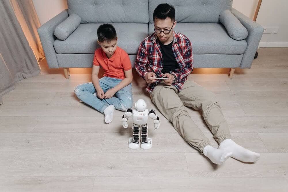 Man teaching a kid how to use a robot